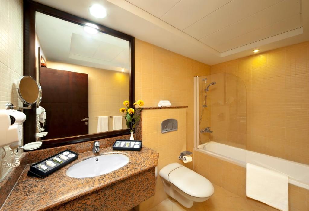 uma casa de banho com um lavatório, um WC e um chuveiro em Corp Executive Hotel Doha Suites em Doha