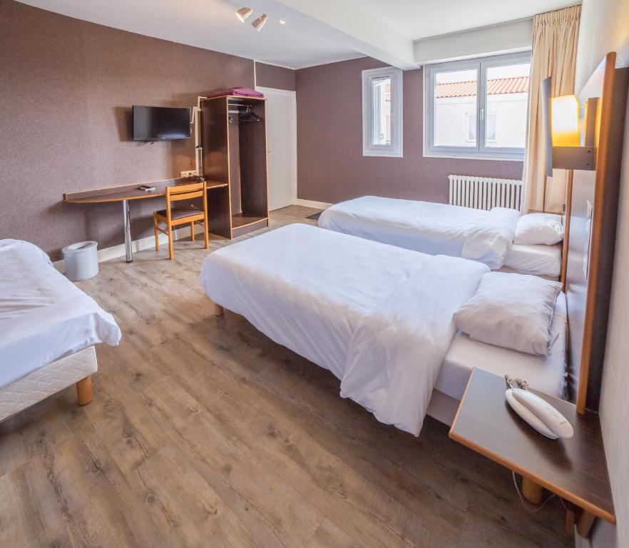 ラ・ロッシュ・シュル・ヨンにあるHôtel de la Vendéeのベッド2台とデスクが備わるホテルルームです。