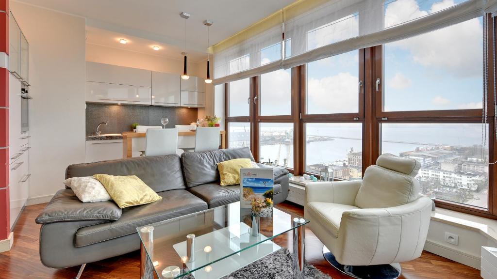 a living room with a couch and a table at Dom & House - Apartamenty Sea Towers in Gdynia