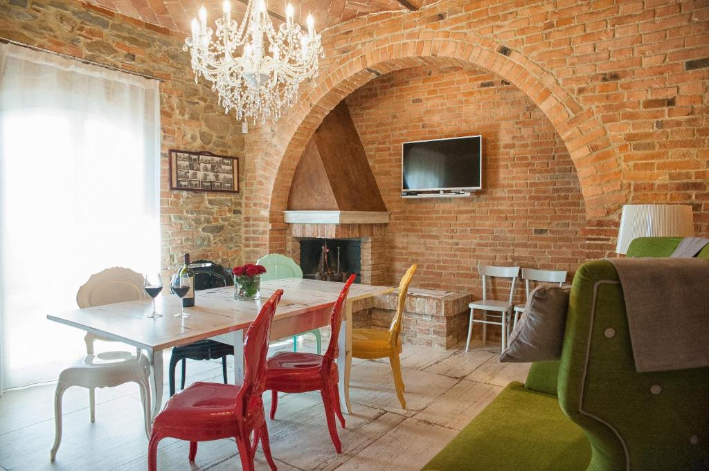 una sala da pranzo con tavolo, sedie e muro di mattoni di Villa Ventotto a Marciano Della Chiana
