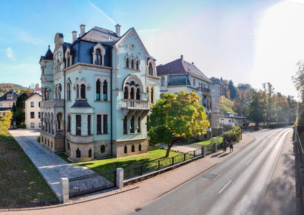 Pension VILLA KLEINE WARTBURG في إيزيناخ: منزل أزرق كبير على جانب الطريق