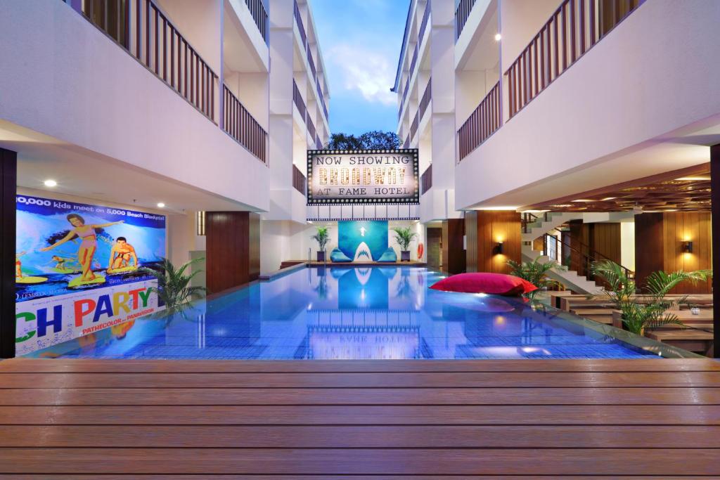 a hotel lobby with a large swimming pool at Fame Hotel Sunset Road in Kuta