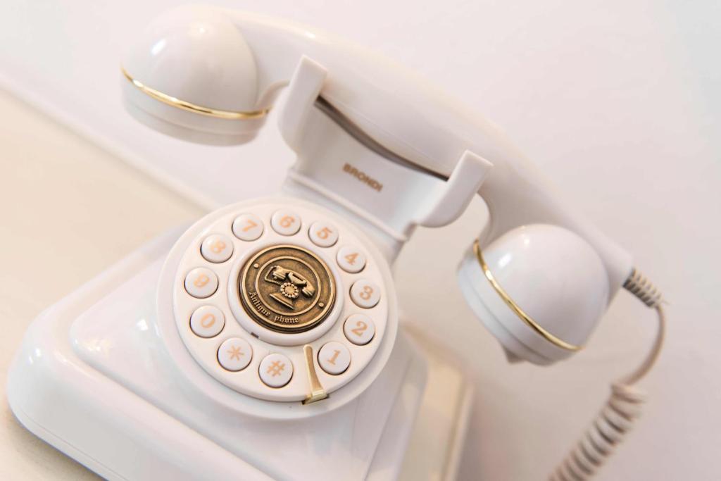 an old fashioned white phone with glasses on top at Borgo Tre Rose in Valiano
