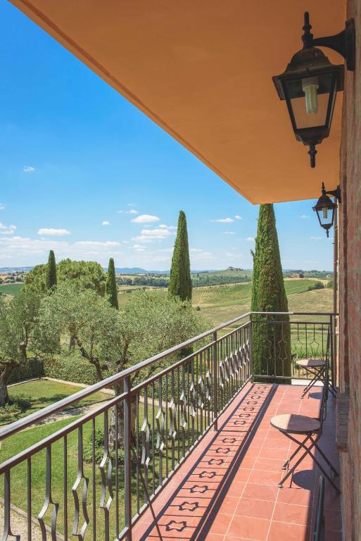 a balcony with a view of the rolling hills and trees at Borgo Tre Rose in Valiano