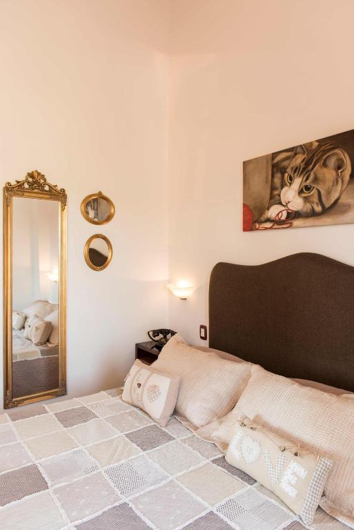 a bedroom with a large bed with a mirror at Borgo Tre Rose in Valiano