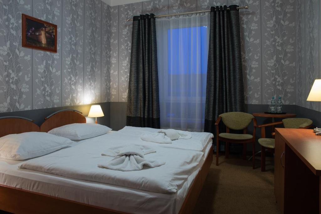 a hotel room with a bed with towels on it at Majewski Hotel & SPA in Malbork