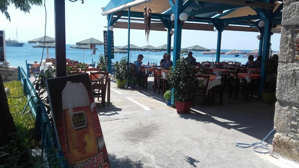 un restaurante con gente sentada en las mesas de la playa en Hotel Tarsanas, en Pythagoreio