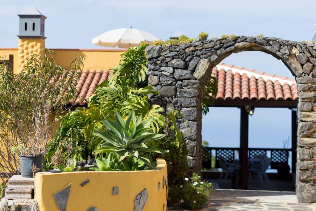 une arche en pierre avec des plantes devant un bâtiment dans l'établissement Finca Casa Yaya, à Icod de los Vinos