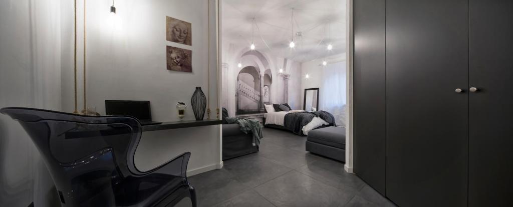 ヴォゲーラにあるSuite Vogue Sforzaのベッド、デスク、椅子が備わる客室です。