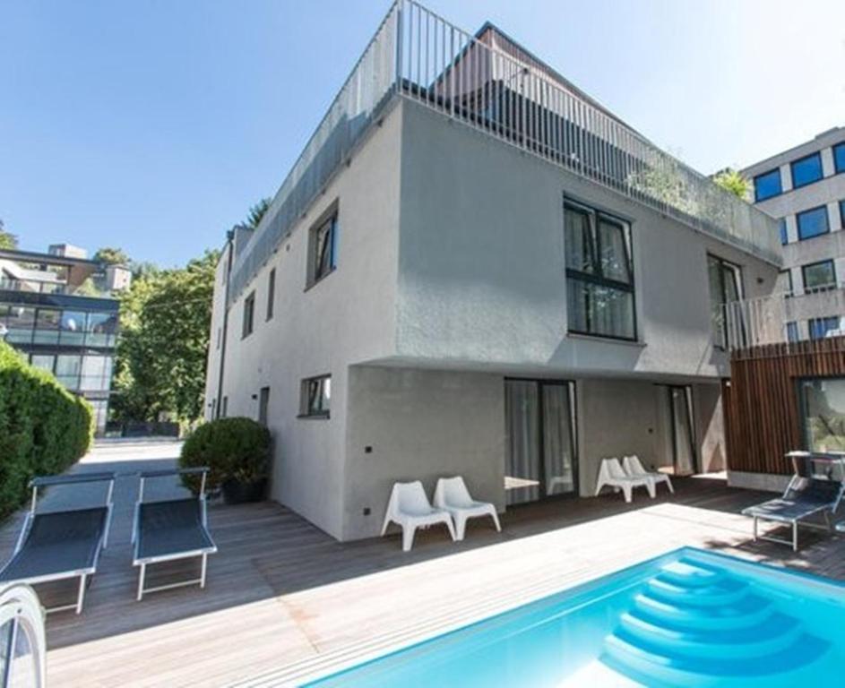 a house with a swimming pool next to a building at Room 4 & 5 Apartments in Salzburg