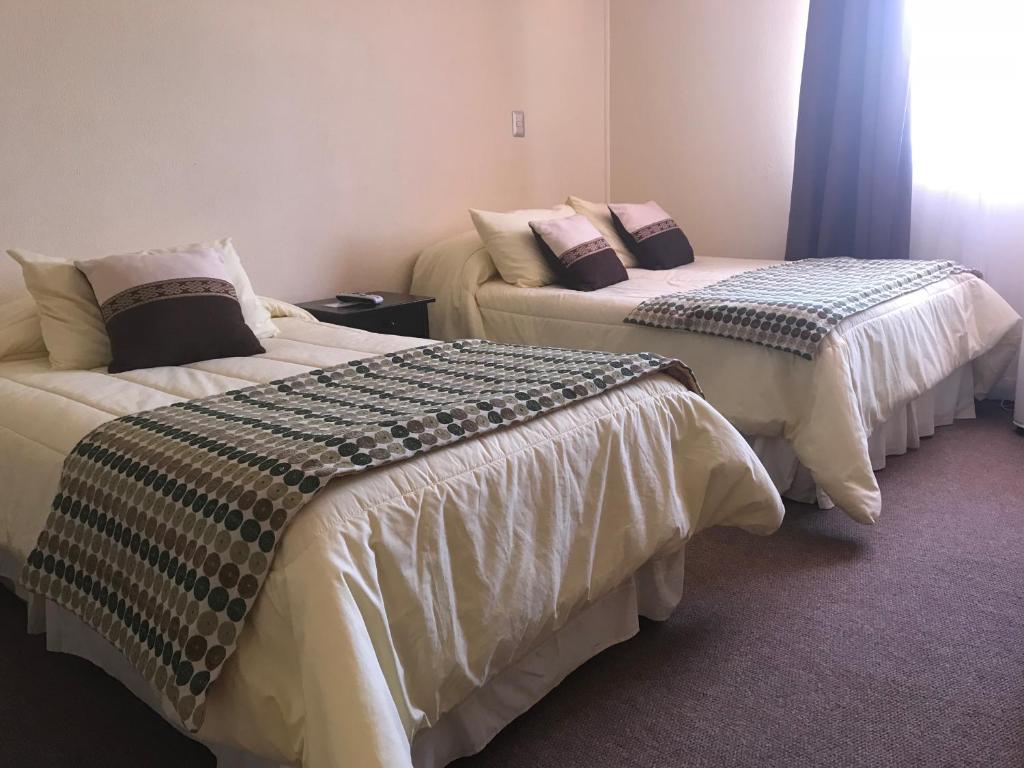 two beds in a hotel room withskirts at Hotel Barba Lá in Combarbalá