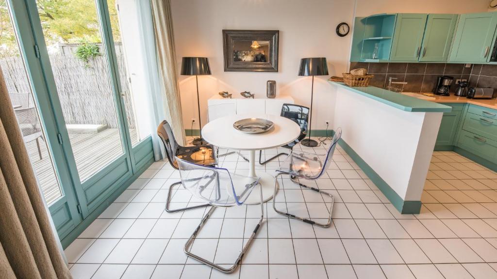 a kitchen with a table and chairs in a room at Cottage "Les GALETS" face au Lac de la forêt d'Orient - Les Cottages du Belvédère in Mesnil-Saint-Père