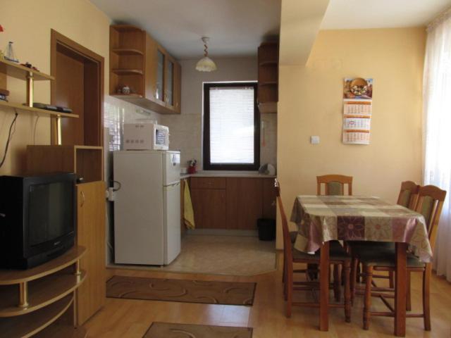 cocina y comedor con mesa y nevera en Villa Shipkovo, en Shipkovo