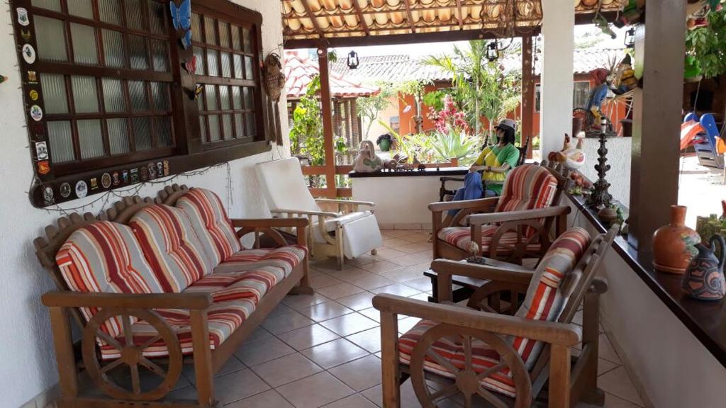 Habitación con sillas, mesa y barra. en Pousada Casa D` Guio, en Rio das Ostras