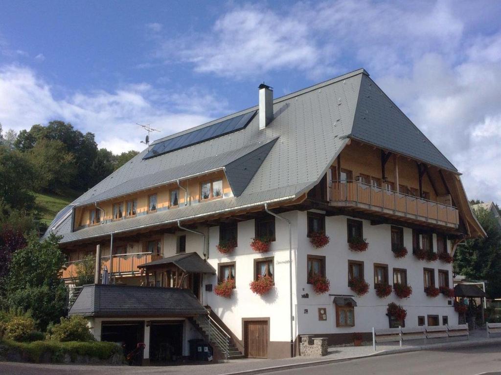 un gran edificio blanco con techo de gambrel en Schwarzwaldhaus Simmelehof, en Lenzkirch