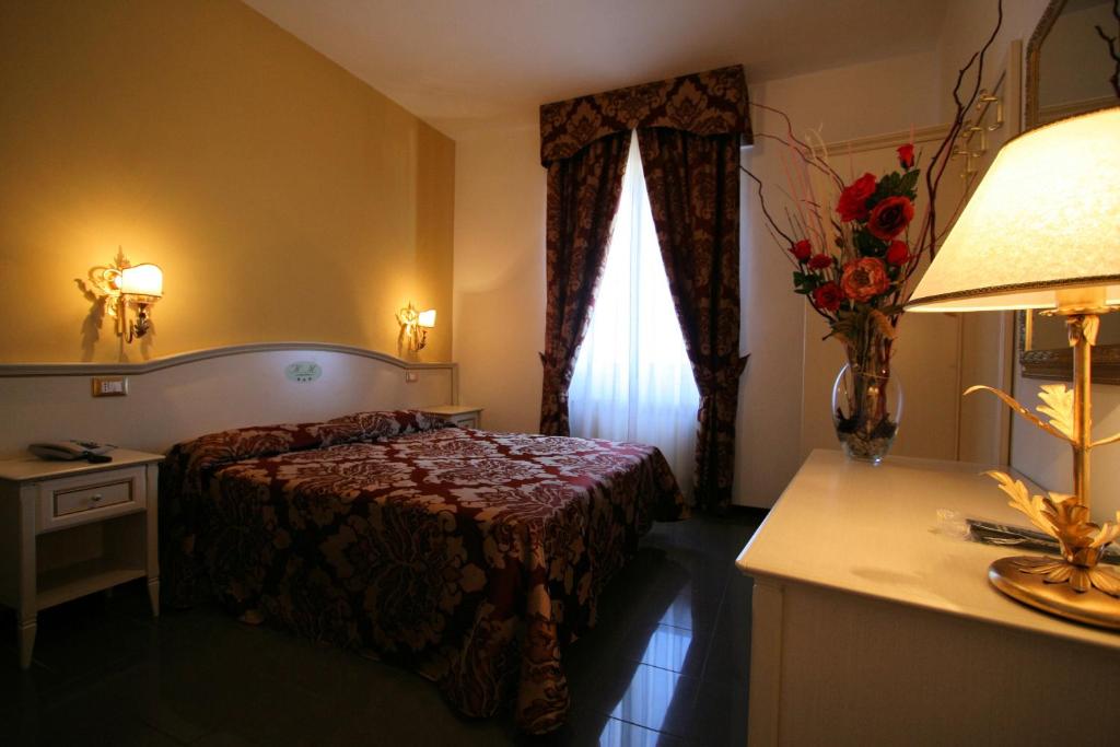 a hotel room with a bed and a window at Hotel La Meridiana in Anghiari