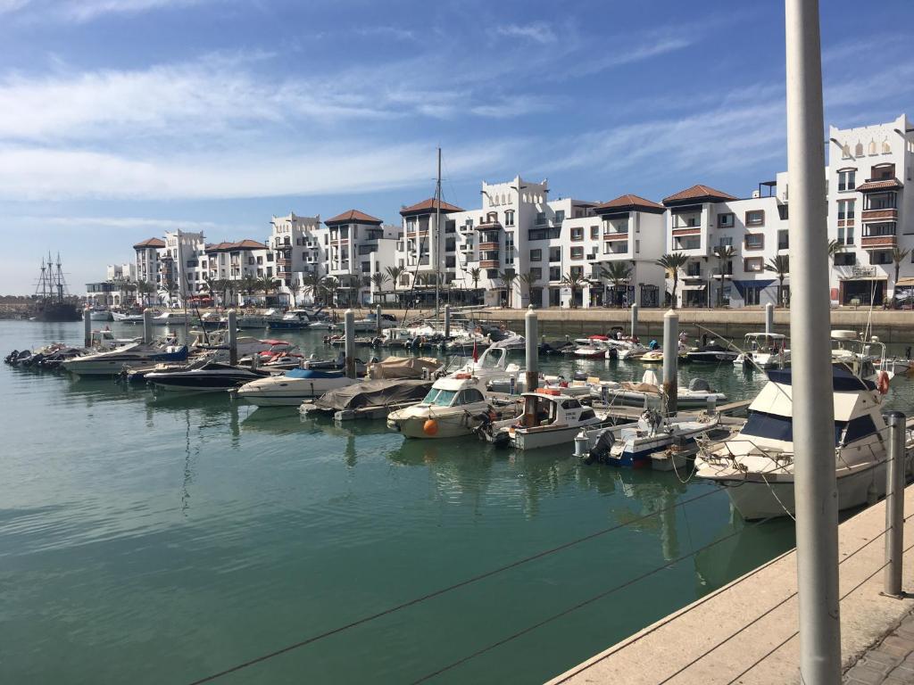 een groep boten aangemeerd in een jachthaven met gebouwen bij Marina Apartment Agadir in Agadir