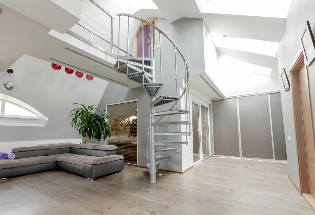 里加的住宿－Penthouse Apartment with Terrace，客厅设有螺旋楼梯和沙发