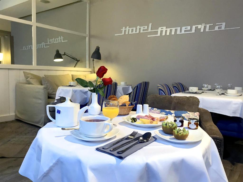 a table with plates of food and coffee on it at Hotel America in Cannes