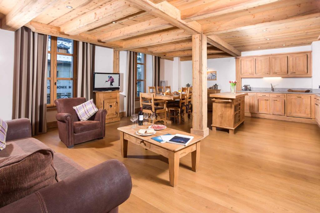 a living room with a table and a kitchen at Le Kursaal Apartment - Chamonix All Year in Chamonix