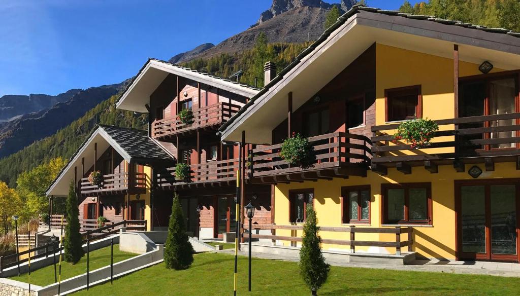 un grande edificio con una montagna sullo sfondo di Residence Le Marmotte a Gressoney-la-Trinité