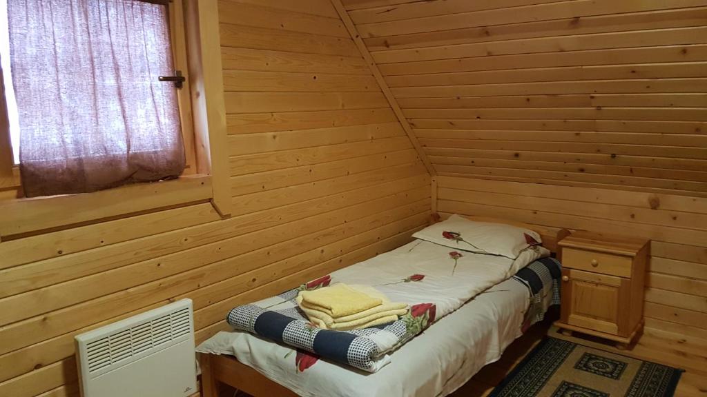 a small room with a bed in a log cabin at Chalet Taffski in Borovets