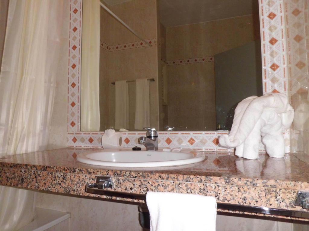 encimera con lavabo y espejo en Apartamentos Chinyero, en Puerto de la Cruz