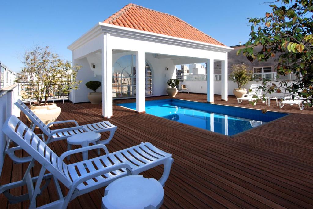eine Terrasse mit einem Pavillon und einem Pool in der Unterkunft Vitória Hotel Residence NewPort in Campinas