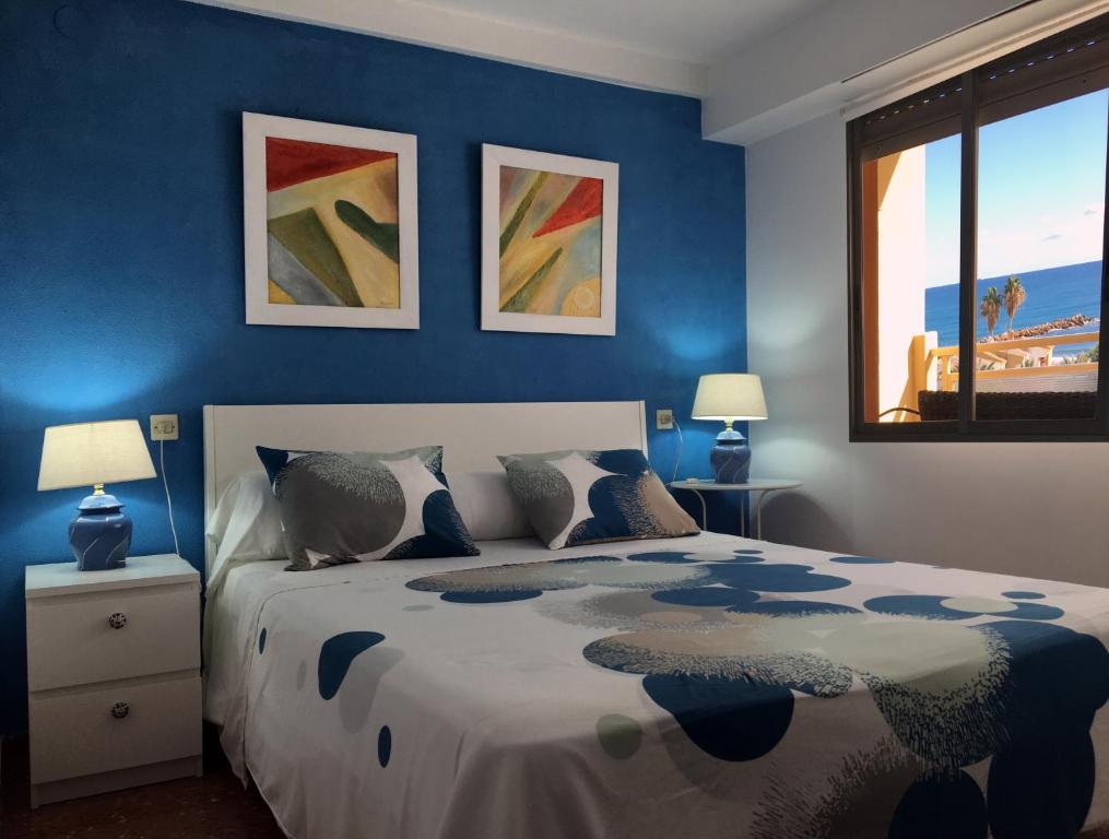 a bedroom with blue walls and a bed with pillows at Apartamento PuigVal in El Puig