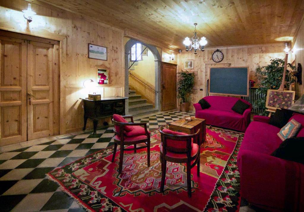 sala de estar con muebles de color rojo y suelo a cuadros en B&B Aquarelle, en Faggeto Lario 