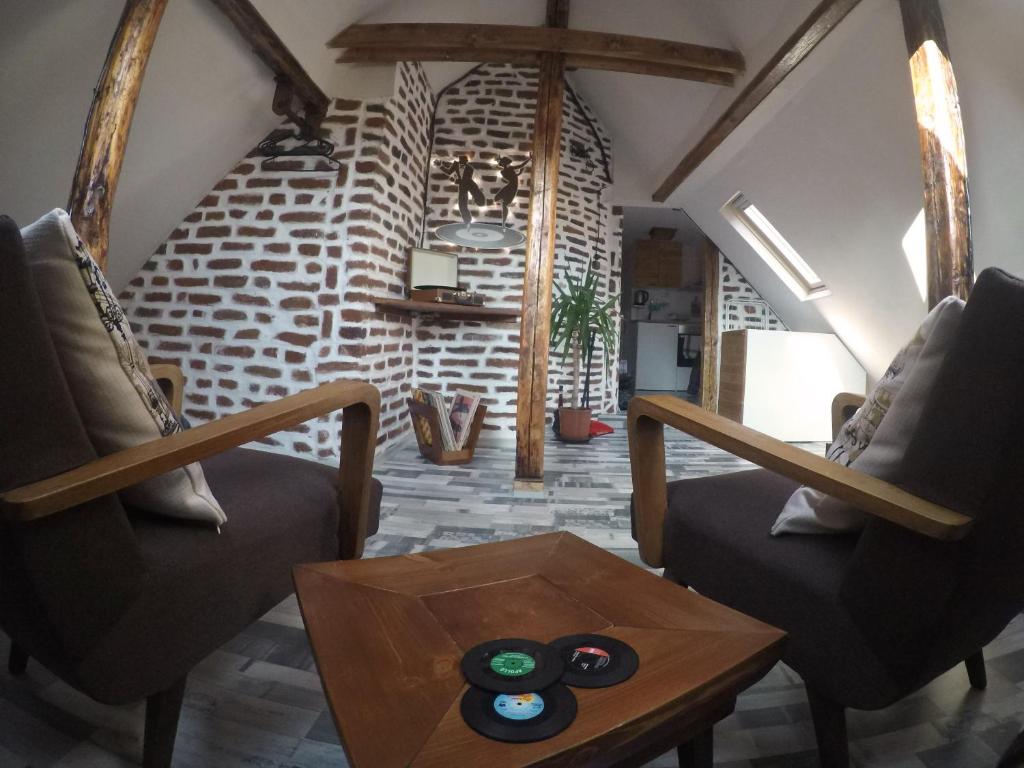 een woonkamer met twee stoelen en een tafel bij Gramophone Sofia Downtown Apartment in Sofia