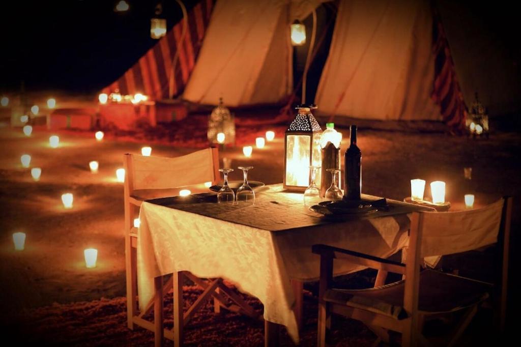 a table with candles on it with lights on it at Luxury Camp By DAR AZAWAD in Mhamid