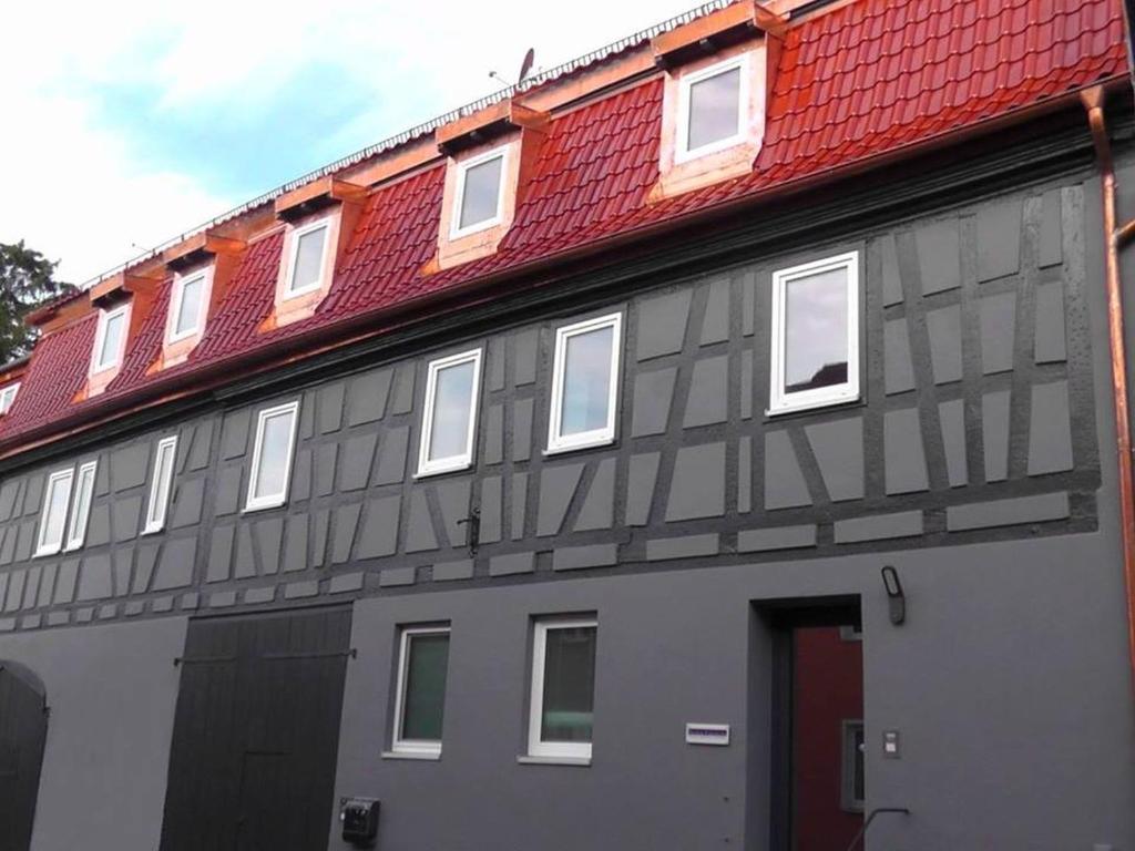 ein graues Gebäude mit rotem Dach in der Unterkunft CityZimmer Eltmann in Eltmann