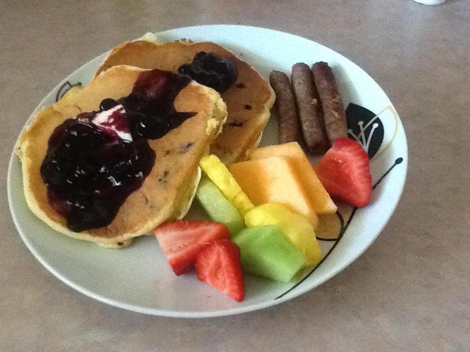 un piatto di cibo con pancake, frutta e cracker di Vintage Merlot Bed and Breakfast a Oliver