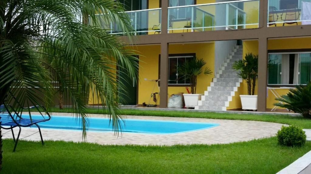 a swimming pool in front of a building at Residencial Alexandre in Matinhos