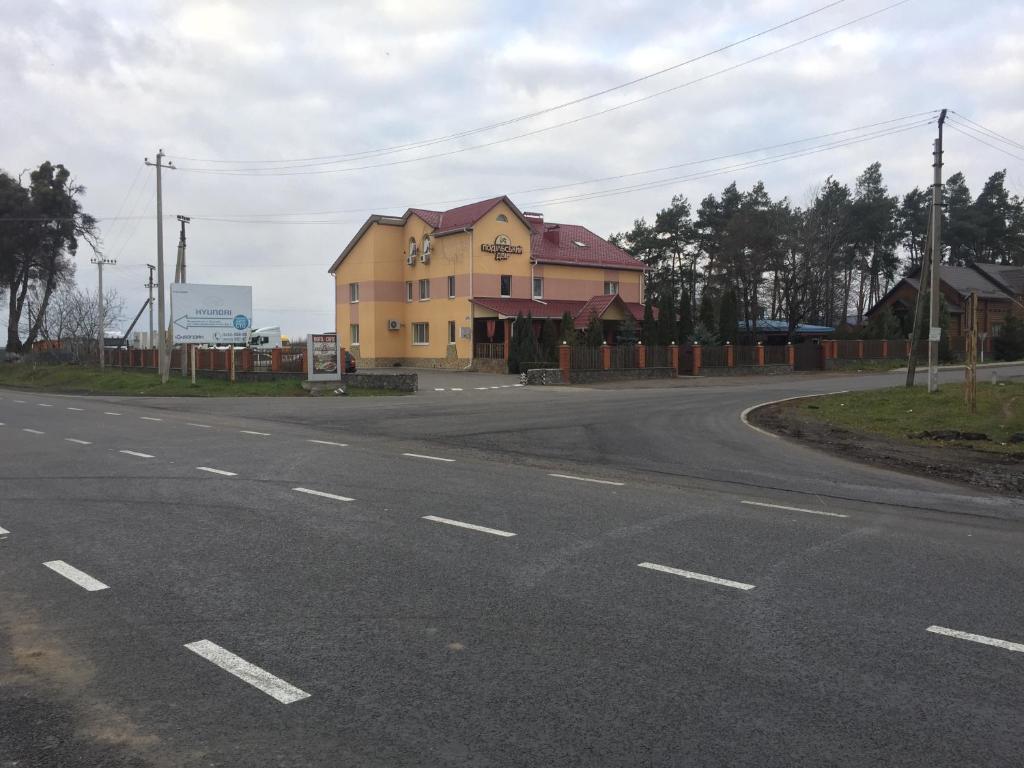 ein gelbes Gebäude an der Straßenseite in der Unterkunft Podilskii Dvir in Yakushintsy