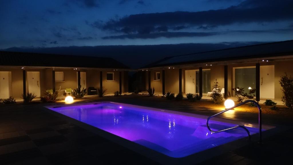 una piscina iluminada por la noche con luces moradas en Magrine Castelfranco Veneto en Castelfranco Veneto