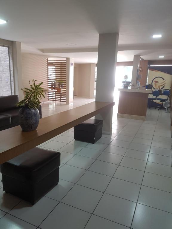 eine Lobby mit einem Tisch und einer Topfpflanze in der Unterkunft Leal Classic Hotel in Itabuna