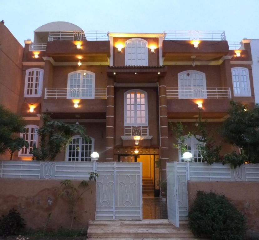 uma casa grande com uma cerca branca em frente em Luxor Star Apartments em Luxor