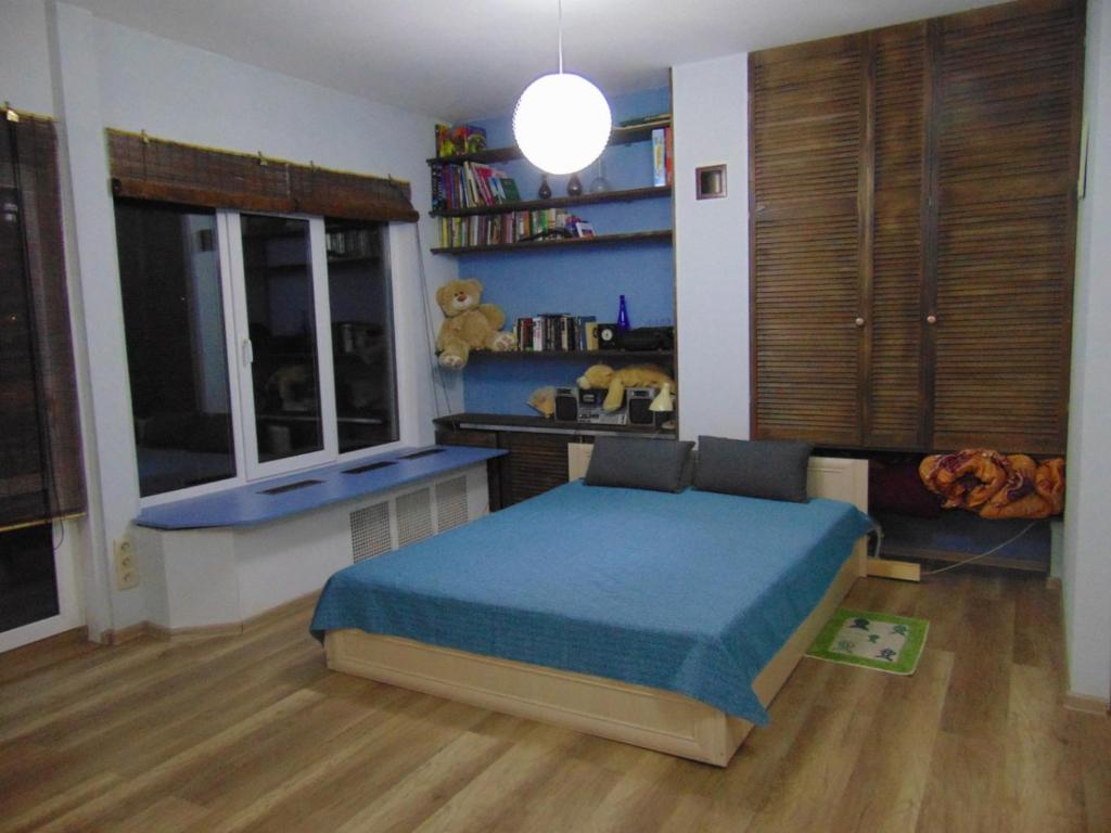 ein Schlafzimmer mit einem blauen Bett und einem Fenster in der Unterkunft Bambukovyi Gai in Kiew