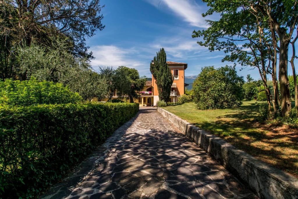 a walkway leading to a house with a hedge at Cascina La Scala in Salò