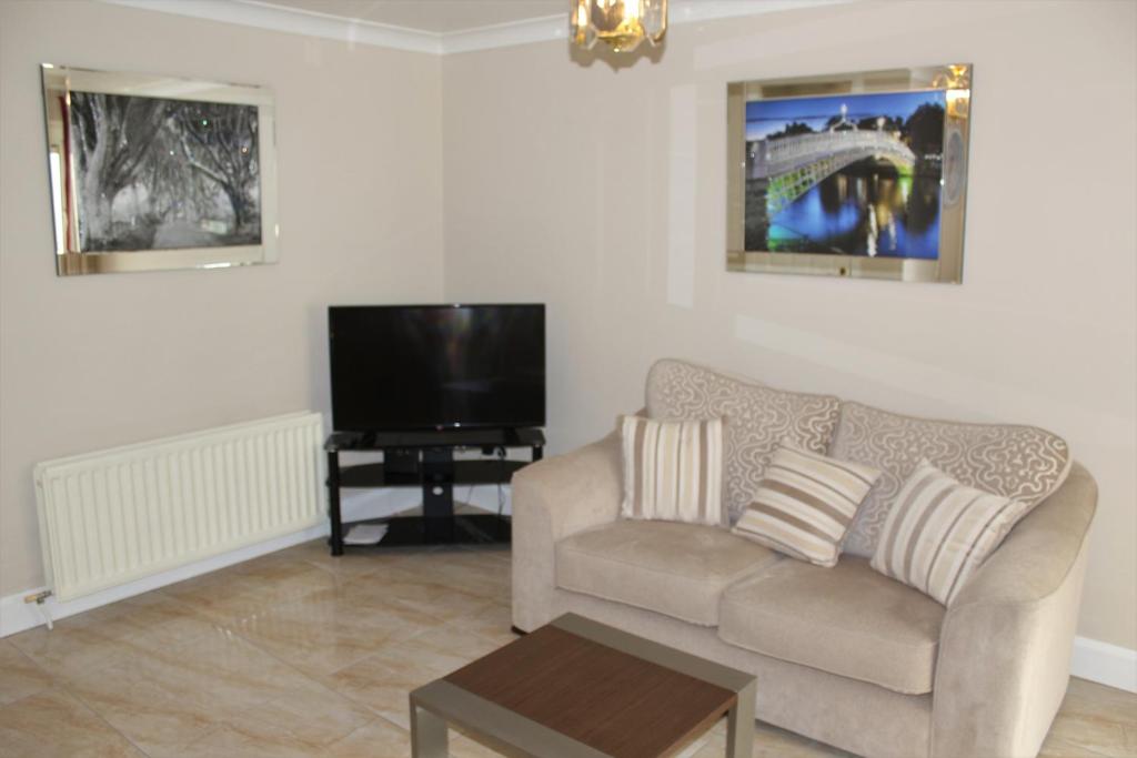 a living room with a couch and a tv at Wild Atlantic Accommodation 2G Orchard Crescent in Letterkenny