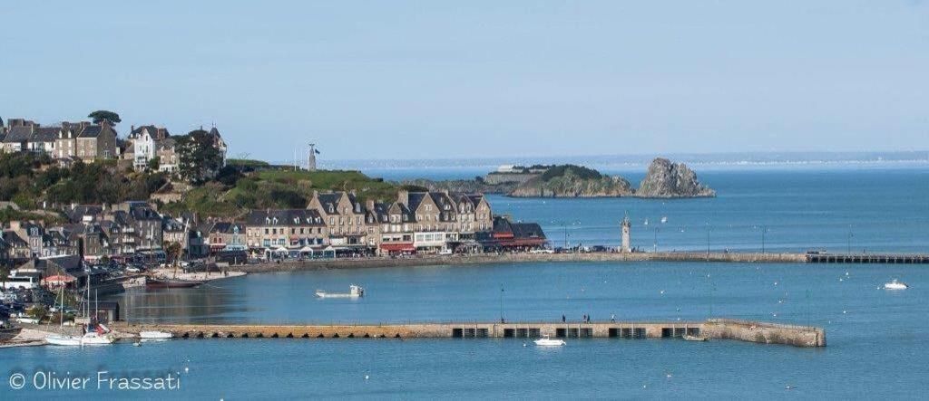 une grande étendue d'eau avec une ville et un port dans l'établissement La Capitainerie, à Cancale