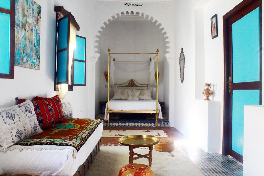 a living room with a couch and a bed at Riad Khmisa in Tetouan