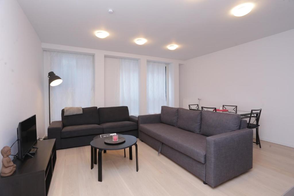 uma sala de estar com um sofá e uma mesa em European institutions apartments em Bruxelas