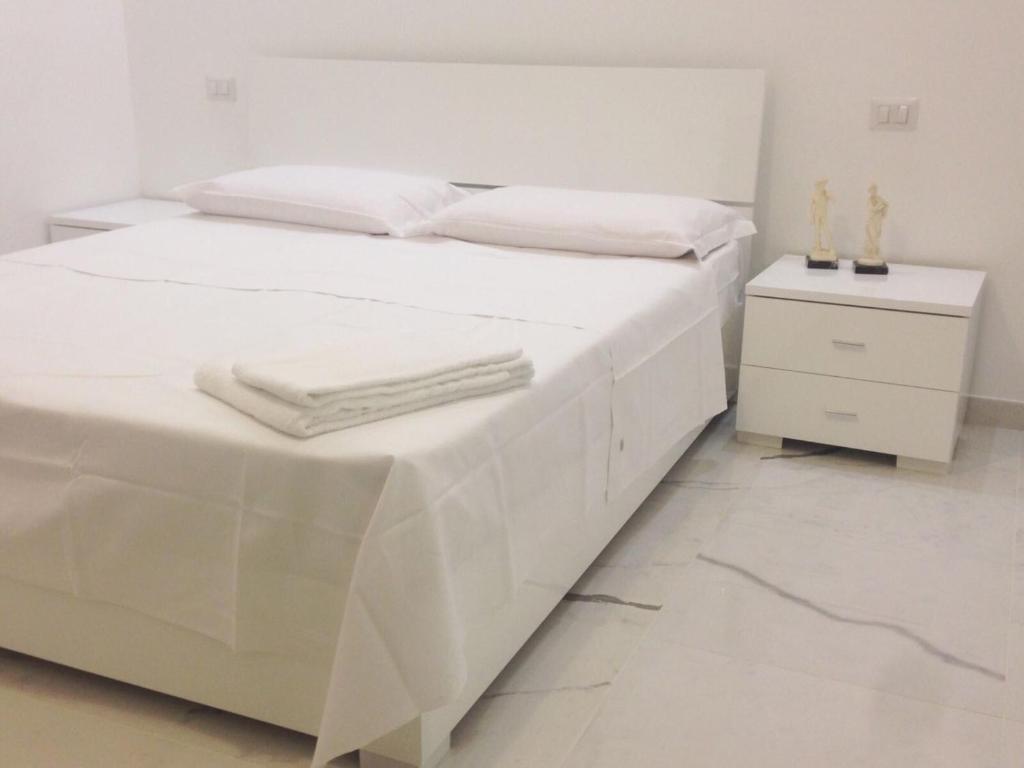 - un lit blanc avec des draps blancs et des serviettes dans l'établissement B&B Palombini, à Rome