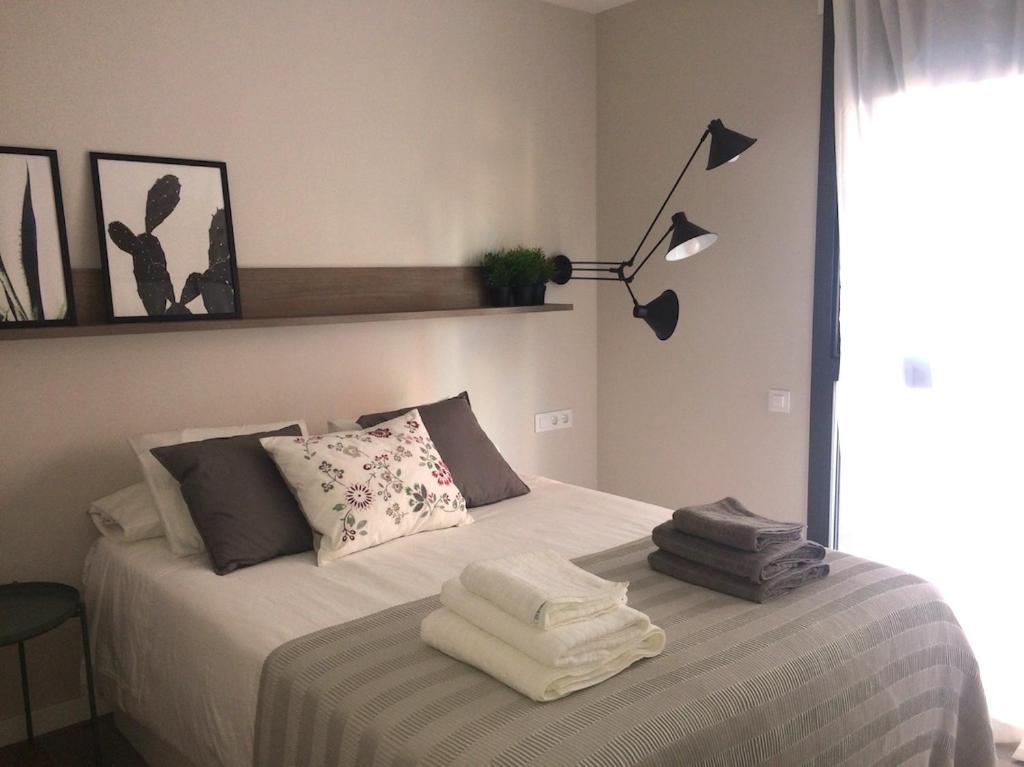 1 dormitorio con 1 cama con lámpara. en Unique Apartments, en Hospitalet de Llobregat