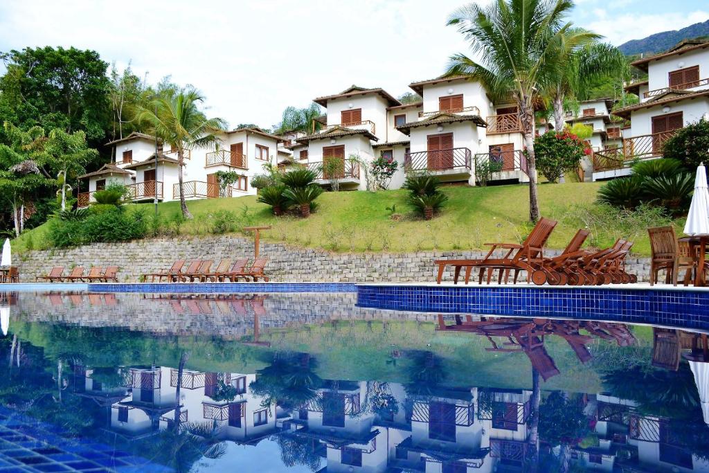 uma piscina em frente a um resort em Bangalo-Yacamim Praia do Curral em Ilhabela