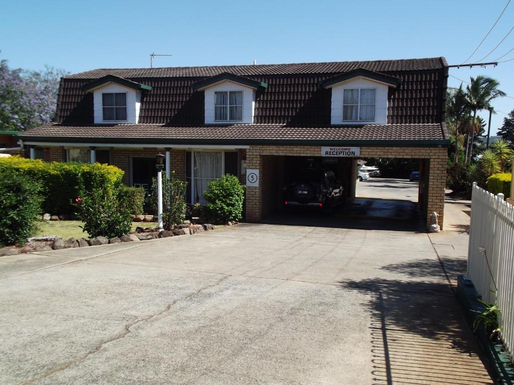 a house with a garage with a car in it at Bridge Street Motor Inn in Toowoomba