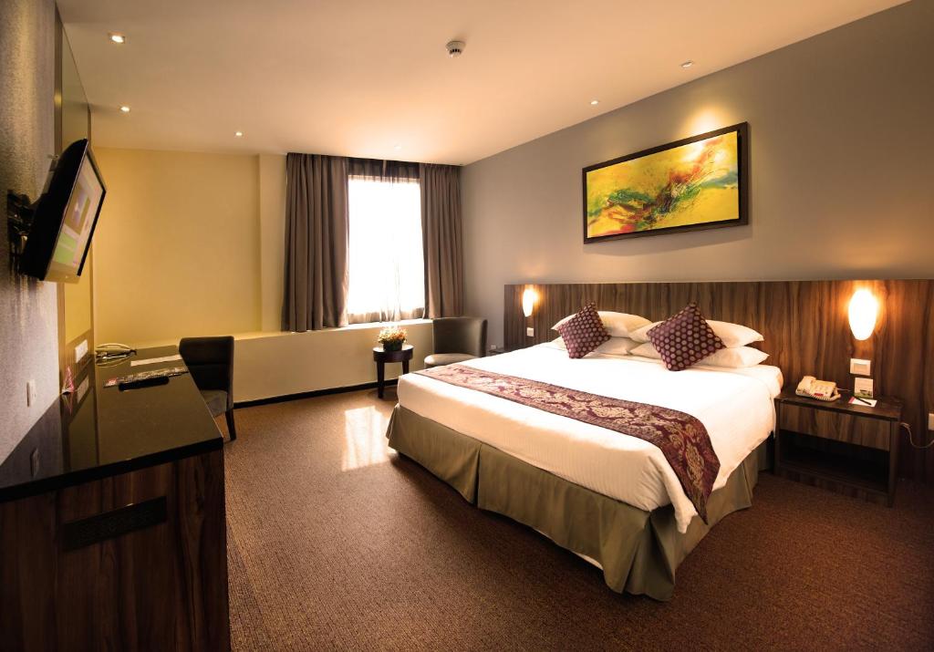 Hotel Royal Kuala Lumpur في كوالالمبور: غرفه فندقيه سرير كبير وتلفزيون